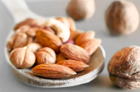 Almonds, Hazelnuts, Walnuts, Cashew Nuts in a Wooden Spoon, and Three Whole W Stock Photos