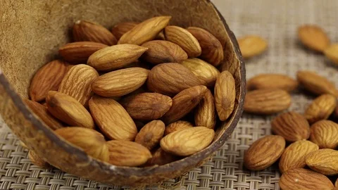 Almonds lie in two empty coconut shells Stock Footage 123821584