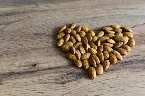 Almonds lying on the table in the form of a heart. Copy space Stock Photos