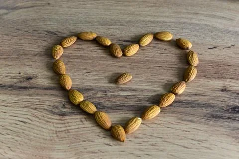 Almonds lying on the table in the form of a heart Stock Photos