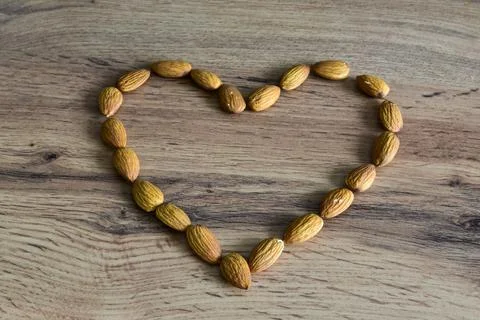 Almonds lying on the table in the form of a heart Stock Photos