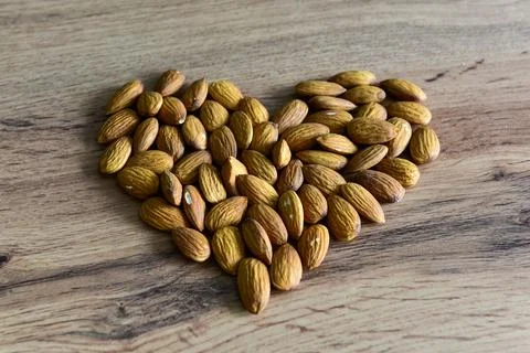 Almonds lying on the table in the form of a heart Stock Photos
