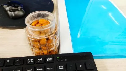 Almonds nut on office Table and in transparent box for healthy snacks diet plan Stock Photos