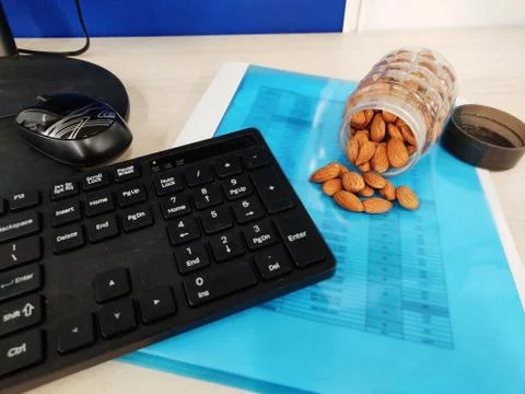 Almonds nut on office Table and in transparent box for healthy snacks diet plan Stock Photos