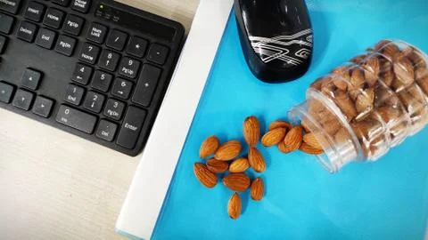 Almonds nut on office Table and in transparent box for healthy snacks diet plan Stock Photos