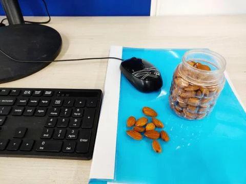 Almonds nut on office Table and in transparent box for healthy snacks diet plan Foto stock