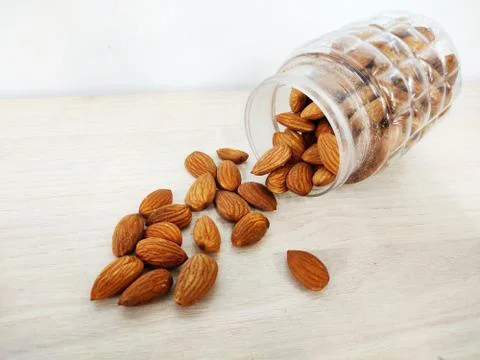 Almonds nut on Table and in transparent box light colour background with space Stock Photos