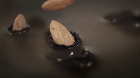 Almonds Nuts Falling Into Liquid Dark Chocolate in 4K Super slow motion Stock Footage 138710030
