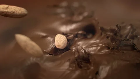 Almonds Nuts Falling Into Liquid Milk Chocolate in 4K Super slow motion Video stock 138710001