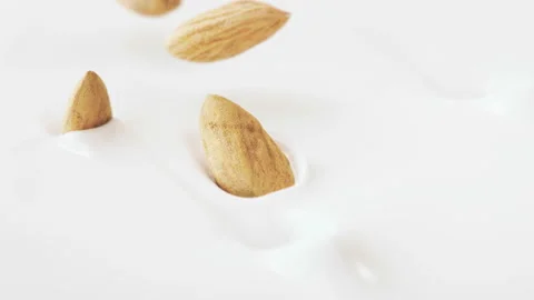 Almonds Nuts Falling Into Liquid Yogurt in 4K Super slow motion Stock Footage 136313129