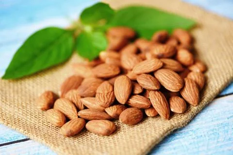 Almonds nuts with leaf , Close up almonds on sack background - Roasted almond Foto stock