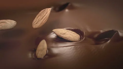 Almonds Nuts Splash Into Liquid Chocolate in 4K Super slow motion Stock Footage 135918296