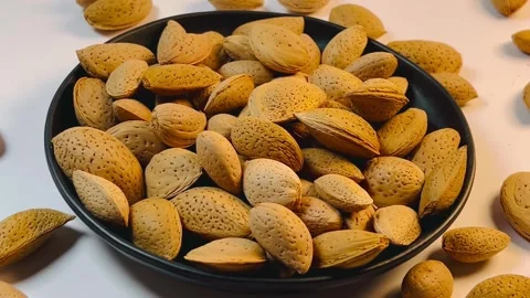 Almonds orbiting close-up shot from left to right on a black plate Vídeos de archivo 336471040