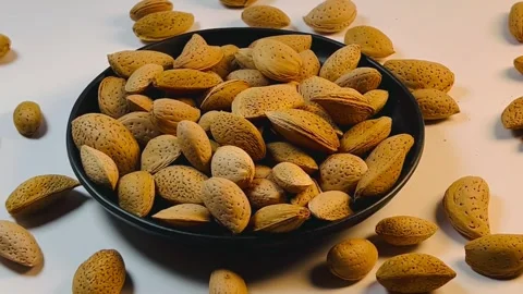 Almonds orbiting close-up shot from right to left on a black plate Vídeos de archivo 336137780