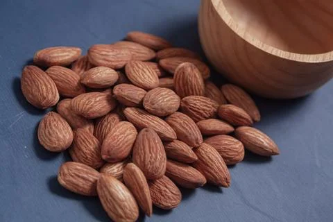 Almonds rest on a simple piece of paper, highlighting their natural texture.. Stock-Fotos