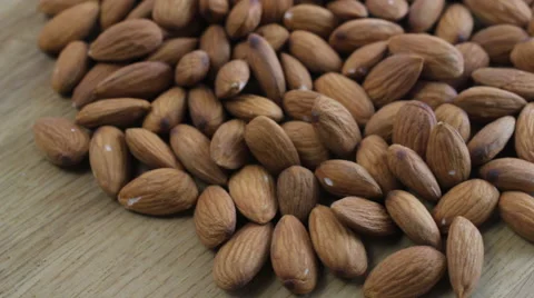 Almonds rotating on wooden table close up Stock Footage 60404299
