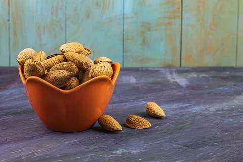 Almonds with shells in red dishes. Stock Photos