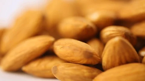 Almonds spinning on the surface. Overhead view. Colors out of camera. Stock Footage 94142991