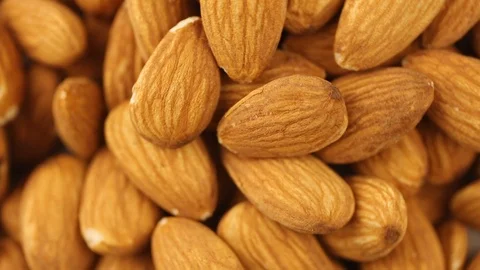 Almonds spinning on the surface. Overhead view. Colors out of camera. Stock Footage 94142998