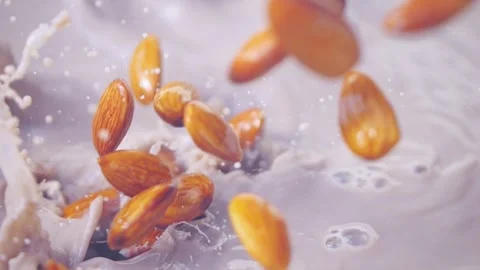 Almonds splashing into chocolate milk with bubbles and ripples in slow moti.. Stock Footage 287998926