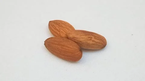 Almonds on a turntable on white background. Macro shot. Peeled almond nuts, Stock Footage 275227196
