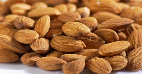 Almonds on white rotating table close-up Stockbeeldmateriaal 122051445
