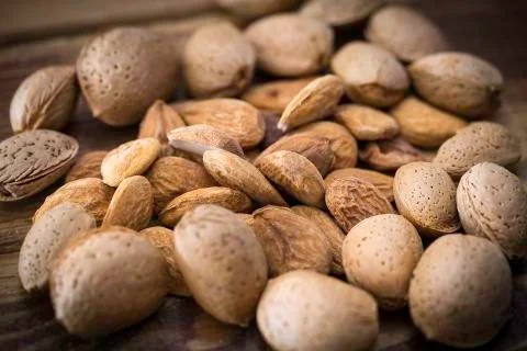 Almonds on a wooden table Stock Photos