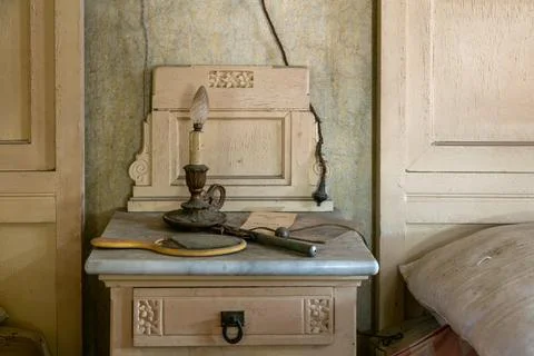 Almost burnt candle on a bedside table in a bedroom, in an abandoned house. urbe Stock Photos