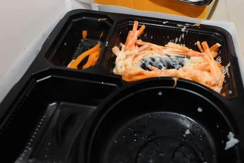 An almost empty black plastic bento box showing leftover shredded carrots w.. Stock Photos