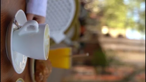 Almost empty cup of coffee in white cup in street outside cafe 스톡 동영상 242347821