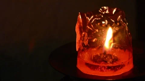 Almost finished red candle with plastic pack and orange and yellow fire light. Stock Footage 145297577