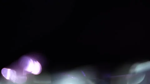 The almost opaque bokeh light leaks into the black area and moves to the left. Stock Footage 315320547