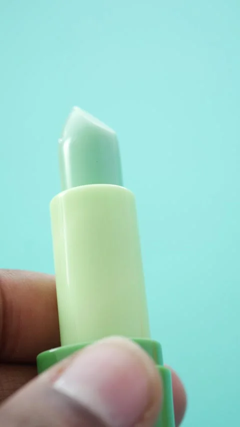 Aloe vera lip balm held against a light blue background Stock Footage 308435657