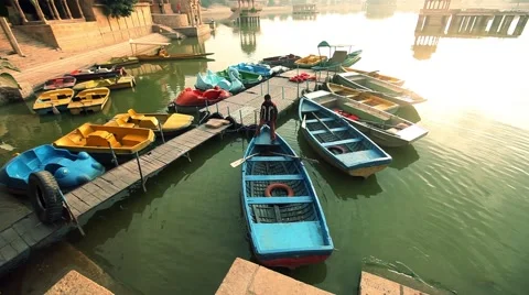 Alone boy standing on a boad at gadisahr lake rajsthan india Stock Footage 45171980