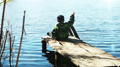 Alone boy throw rocks in the lake water Stock Footage 32303000