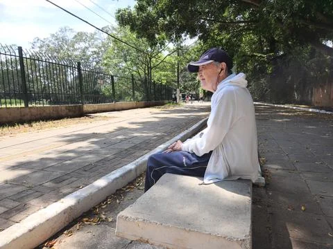 AS Alone elderly man sitting on a park  in Sao Paulo, Brazil - Dec 2023 Stock Photos