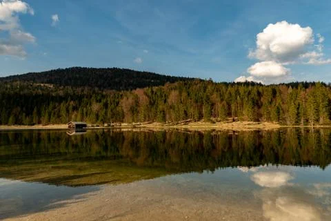 A alone hut in front of a forest with great reflections at Ferchensee Stock Photos