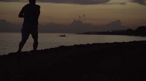 Alone man jogging on the beach at night, steadycam shot, slow motion shot Stock Footage 40314532