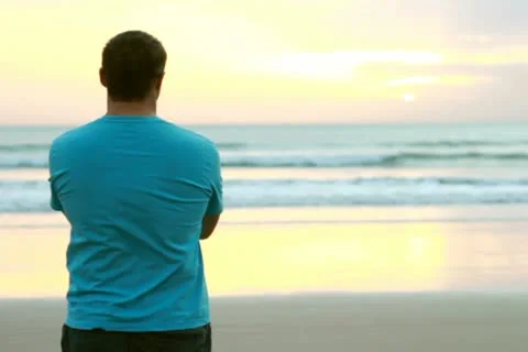 Alone man standing at the beach and looking at sea Stockbeeldmateriaal 10791457