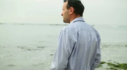 Alone man standing on the seashore, steadicam shot HD Stock Footage 10881808