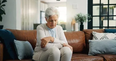 Alone, sad and thinking with old woman on sofa in living room of home for g.. Stock Photos