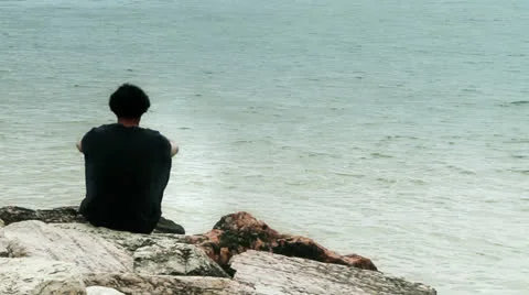 Alone thoughtful man sitting alone at sea Stock Footage 22935268
