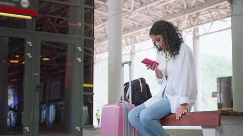 Alone woman passenger on empty platform of suburban trains, sitting on bench Stock Footage 232415355