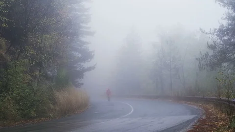 Alone young man lost in the fog, walking on empty road Stock Footage 119384353