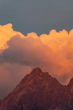 Alpenglow Mountain Peak With Dramatic Orange Clouds and Sunset Sky Over Rug.. Stock-Fotos