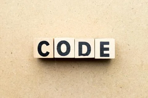 Alphabet letter block in word code on wood background 库存照片