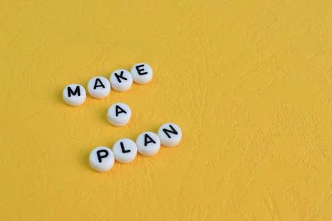 Alphabet letters with text MAKE A PLAN isolated on a yellow background Stock-Fotos