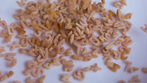 Alphabet soup and numbers falling on a white surface, Slow Motion 1000fps Stock Footage 149154809