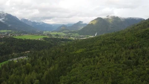 Alpine bright green fields and mountains, dense forests. The hills stretch into  Stock Footage 290079180