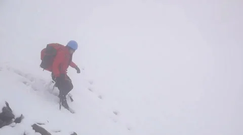 Alpine climber cautiously walking down the avalanche terrain Stock Footage 43248792